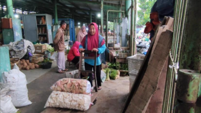 kerja keras ibu di pasar tradisional-Bu Irah, buruh gendong di Pasar Piyungan Yogyakarta, tengah menata barang dagangan milik pelanggan yang membayar jasanya. Potret nyata perjuangan perempuan subuh demi nafkah keluarga di tengah hiruk-pikuk pasar tradisional.(Foto: Tia Aulia)