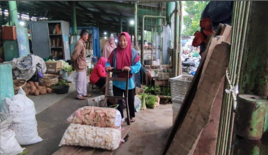 kerja keras ibu di pasar tradisional-Bu Irah, buruh gendong di Pasar Piyungan Yogyakarta, tengah menata barang dagangan milik pelanggan yang membayar jasanya. Potret nyata perjuangan perempuan subuh demi nafkah keluarga di tengah hiruk-pikuk pasar tradisional.(Foto: Tia Aulia)