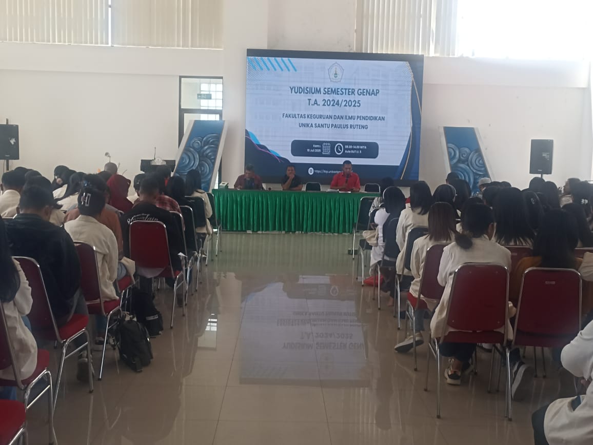 The atmosphere of the Even Semester Graduation Ceremony (Yudisium) for the 2024/2025 Academic Year at the Faculty of Teacher Training and Education (FKIP), Universitas Katolik Indonesia Santu Paulus Ruteng. The event took place on Thursday, July 10, 2025, at the 5th floor of the East Main Building (GUT), attended by students from seven study programs. The photo shows students in academic attire attentively following the session, with faculty leaders speaking from the front stage.